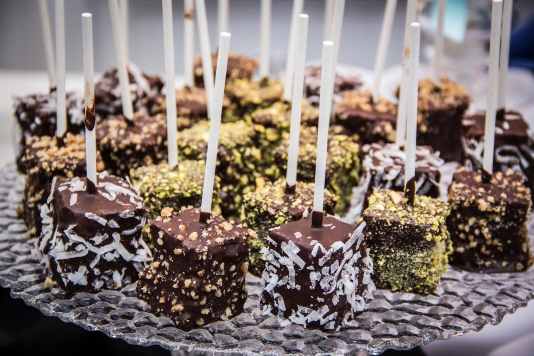 Chocolate-dipped cake pops with pistachio, coconut and nut coatings