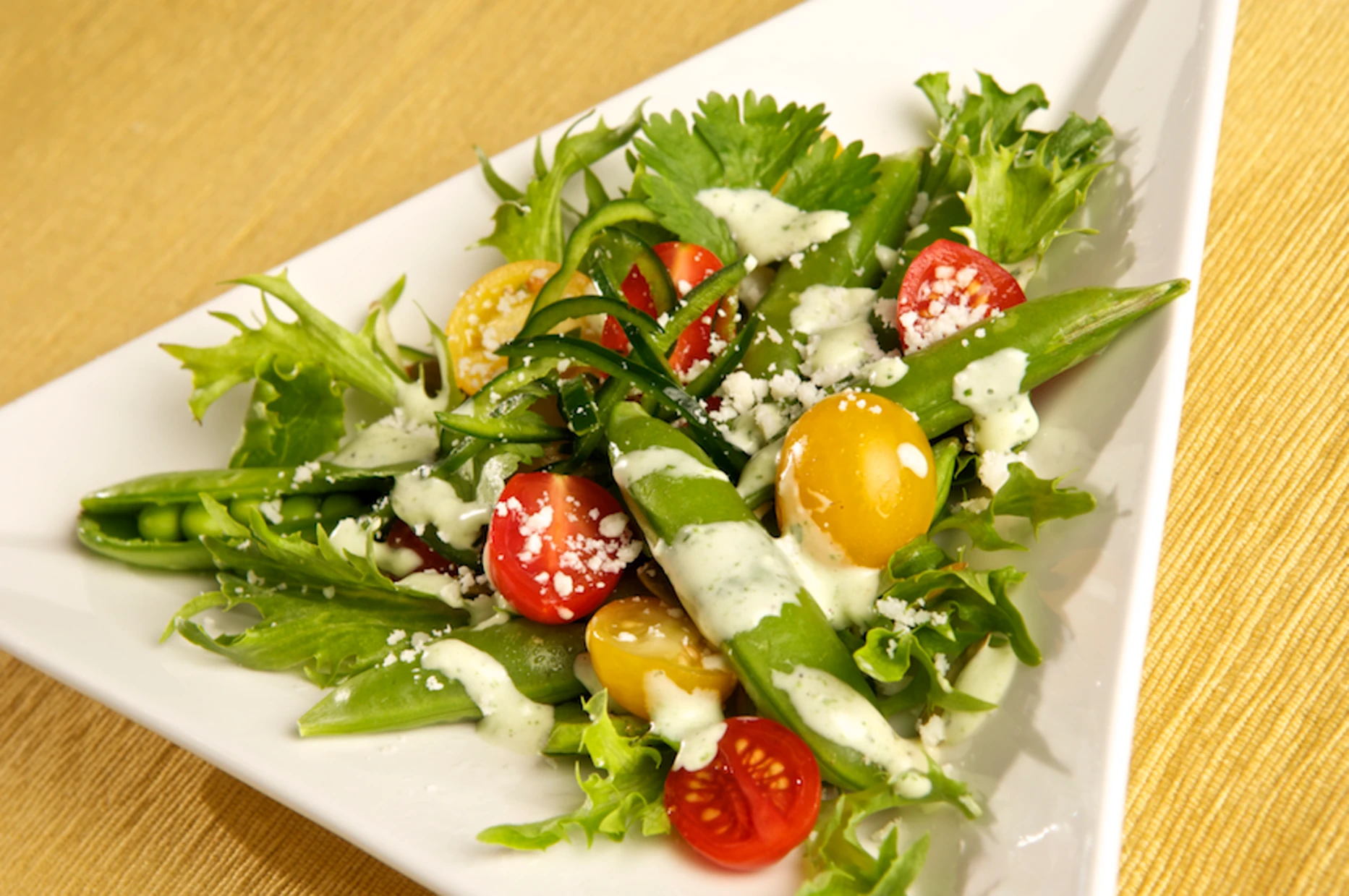 Garden salad with snap peas, heirloom tomatoes and herb dressing