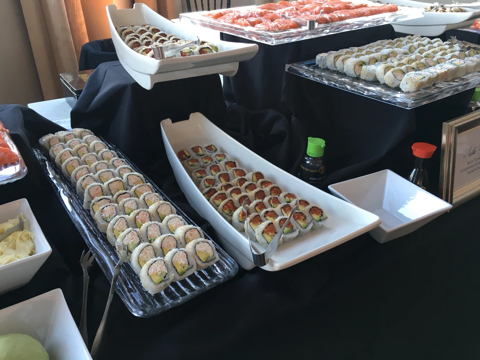 Sushi station with assorted rolls and sashimi platters